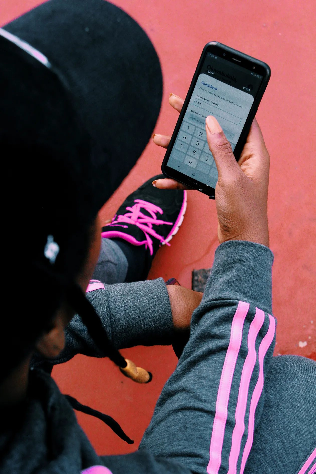 A person holding a smartphone, checking a savings account on a mobile banking app